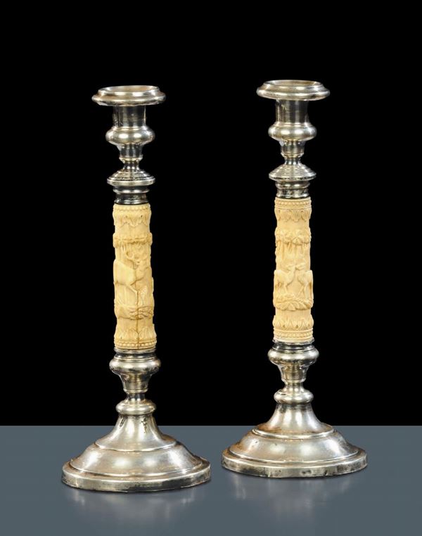 Coppia di candelieri in argento e fusto in avorio scolpito