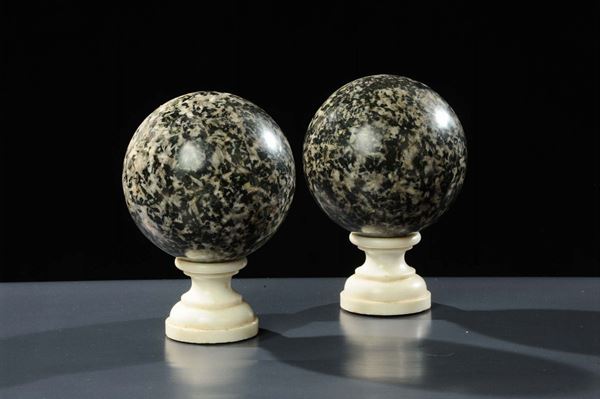 Due sfere in granito con piedistalli in marmo bianco