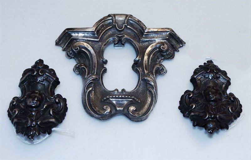 Lotto comprendente coppia di puntali in argento sbalzato con teste di cherubini, XVIII secolo  - Auction Silvers and Jewels - Cambi Casa d'Aste