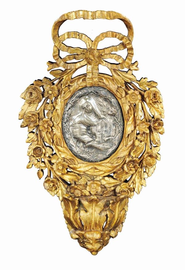 A holy water fount in gilt wood, carved with floral motives, with an oval silver plaque depicting Saint Catherine of Siena. Tuscany 18th century