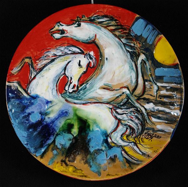 Piatto in ceramica decorato in policromia con teste di cavalli