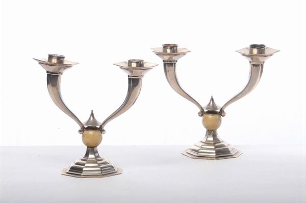 Coppia di candelieri in argento a due luci di gusto Deco, gr. 1000