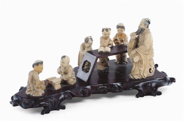 Gruppo di statuine in avorio raffigurante la lezione su base in legno. Cina, Periodo Repubblica, XX secolo