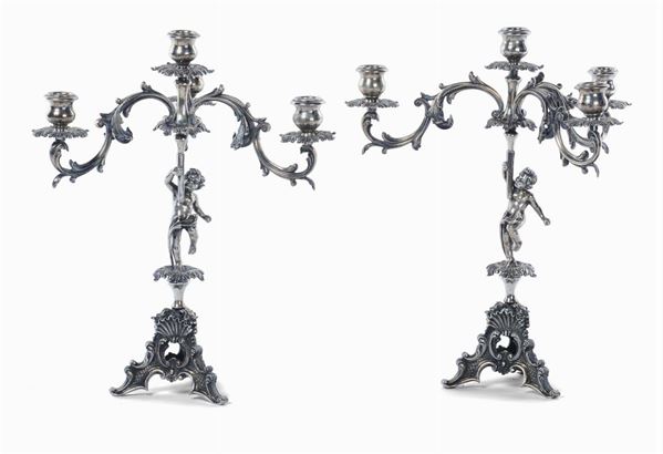 Due candelabri a  in argento a quattro luci, gr. 2800