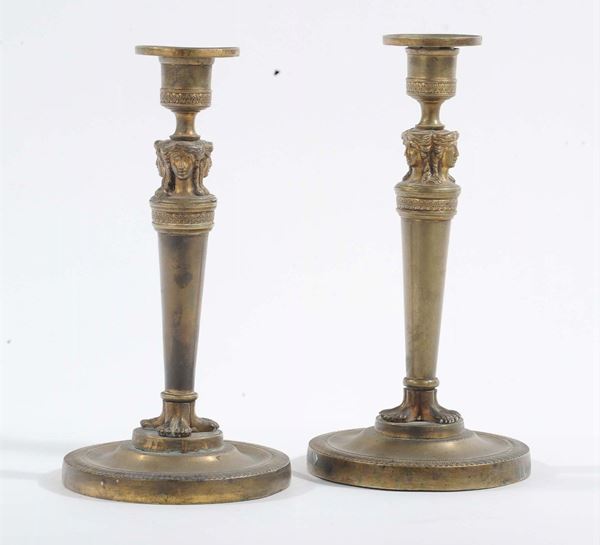 Coppia di candelieri ad una luce in bronzo dorato