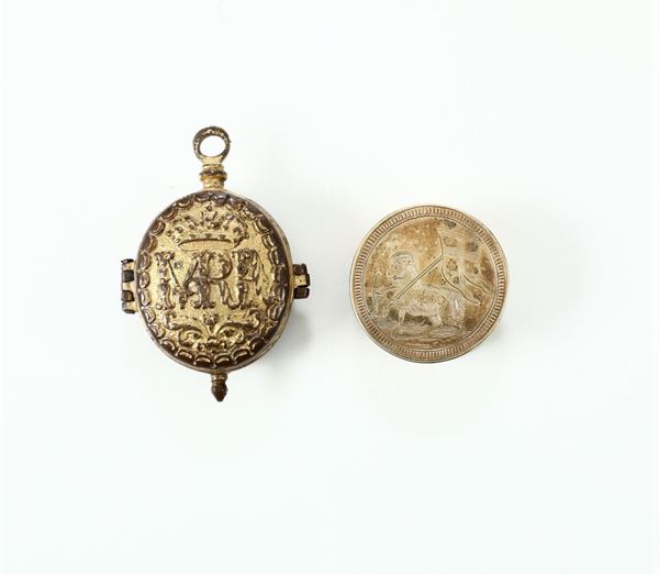 Lotto comprendente pendente reliquiario ovale in rame sbalzato, fuso e dorato con monogrammi “ MRI”  e “IHS”, Spagna e scatola tonda in argento dorato con incisione Agnus Dei