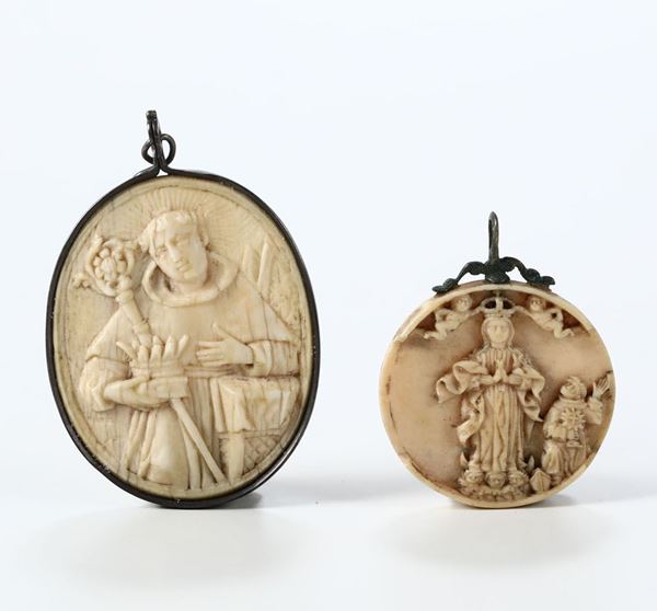 Lotto composto da due pendenti  in avorio scolpito, uno circolare raffigurante Santa Rita e sul retro Madonna con santi e uno ovale con immagine di Santa con corona e finimenti in argento. Italia XVIII secolo