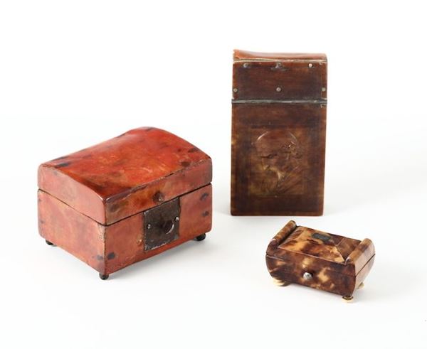 Lotto comprendente tre scatole di cui una in tartaruga rossa, una in tartaruga con testa virile e una a urna, XIX secolo