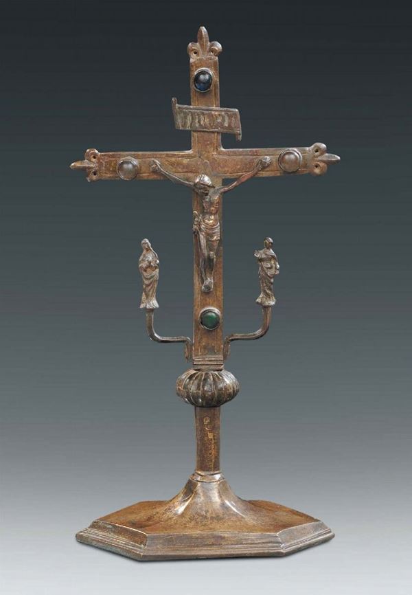 A molten and chiselled bronze altar cross with caboçon stones and suffering figures on the sides, Italy or Spain 15th century, on an hexagonal base