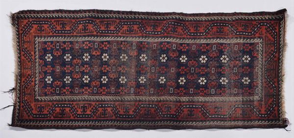 A Baluch rug early 20th century. Localised wear and holes.