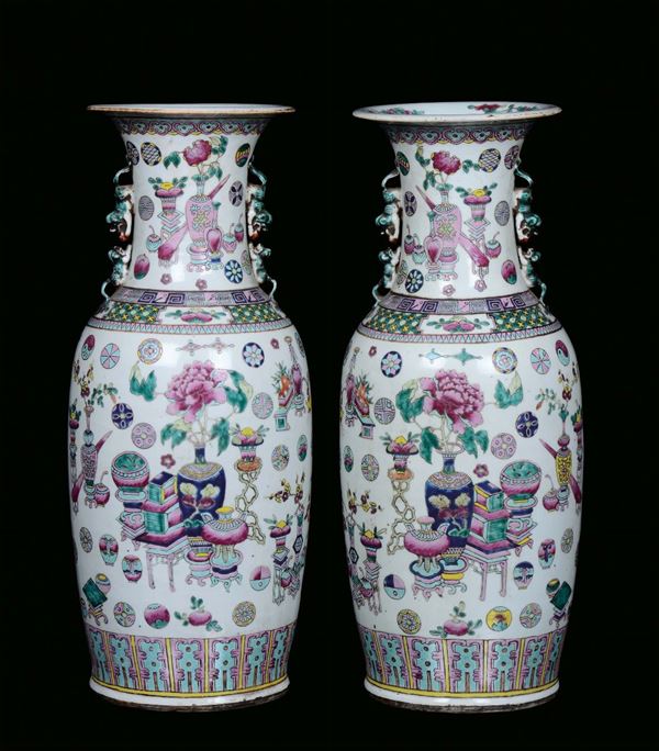 A pair of polychrome porcelain vases, Famille Rose, China, Qing Dynasty, 19th century Decorated with oriental objects, on the neck handles in the shape of a Pho dog