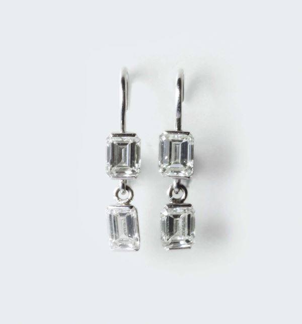 A pair of emerald - cut diamond pendent earrings