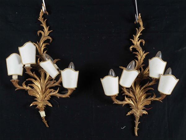Coppia di appliques a quattro luci in legno intagliato e dorato in stile