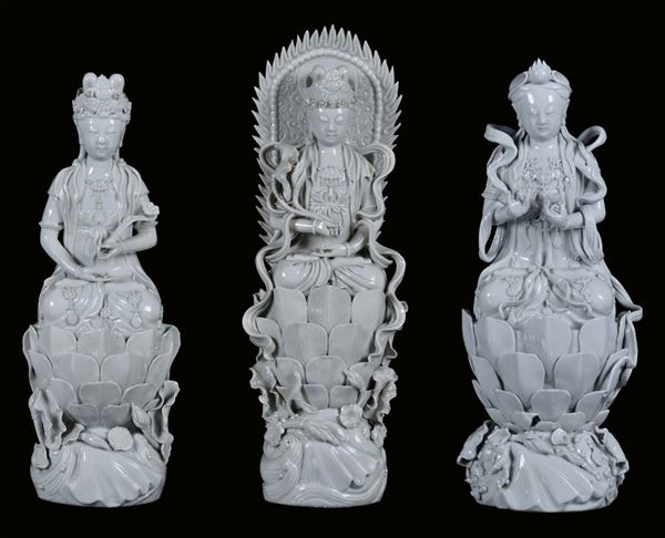 Lot of three Blanc de Chine porcelain Guanyin on a lotus flower, China, Qing Dynasty, beginning 20th century h cm 36, cm 41, cm 37