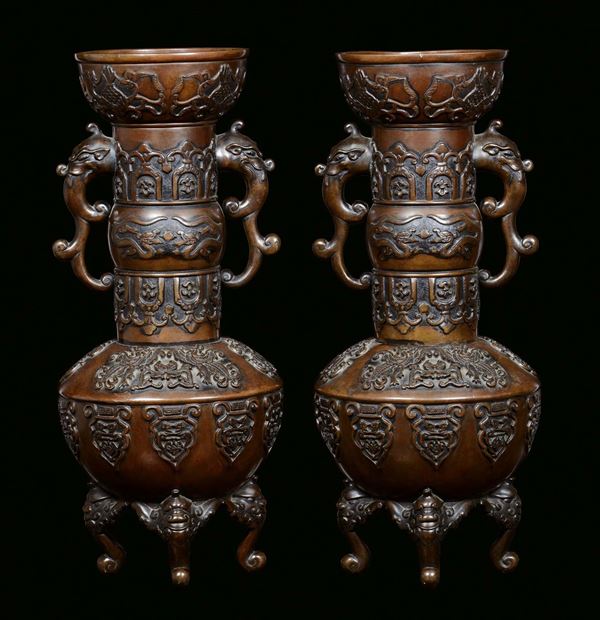 A pair of bronze vases, Japan, 19th century Body polished with stylized decorations, handles in the shape of imaginary animals