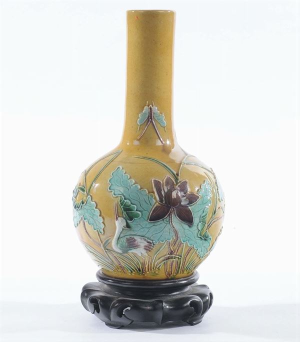A porcelain vase with yellow background, China, 19th century. Ampoule body, decorated with relief animals and vegetation