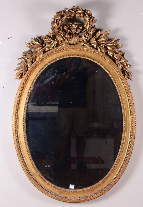 Specchiera ovale in legno intagliato e dorato, XIX secolo