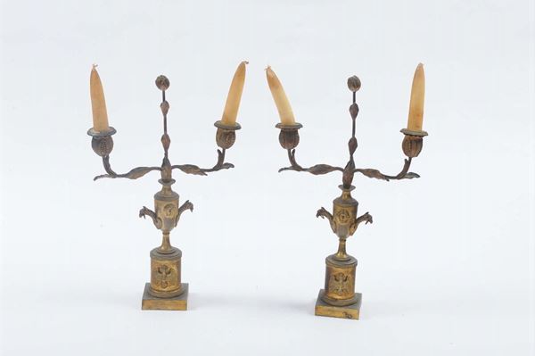 Coppia di candelieri in bronzo dorato a due luci