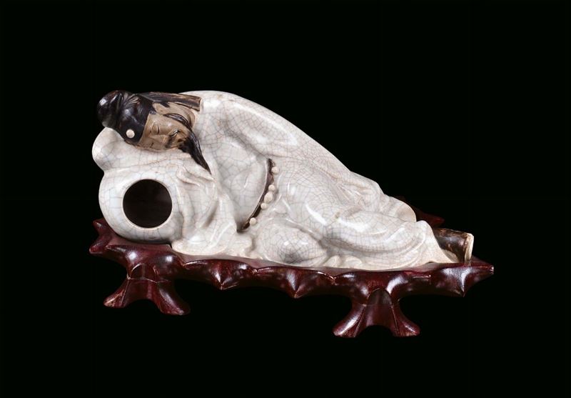 Statua raffigurante saggio sdraiato in porcellana craquele su base in legno di Homu, Cina, periodo Repubblica, XX secolo  - Auction Antique and Old Masters - II - Cambi Casa d'Aste