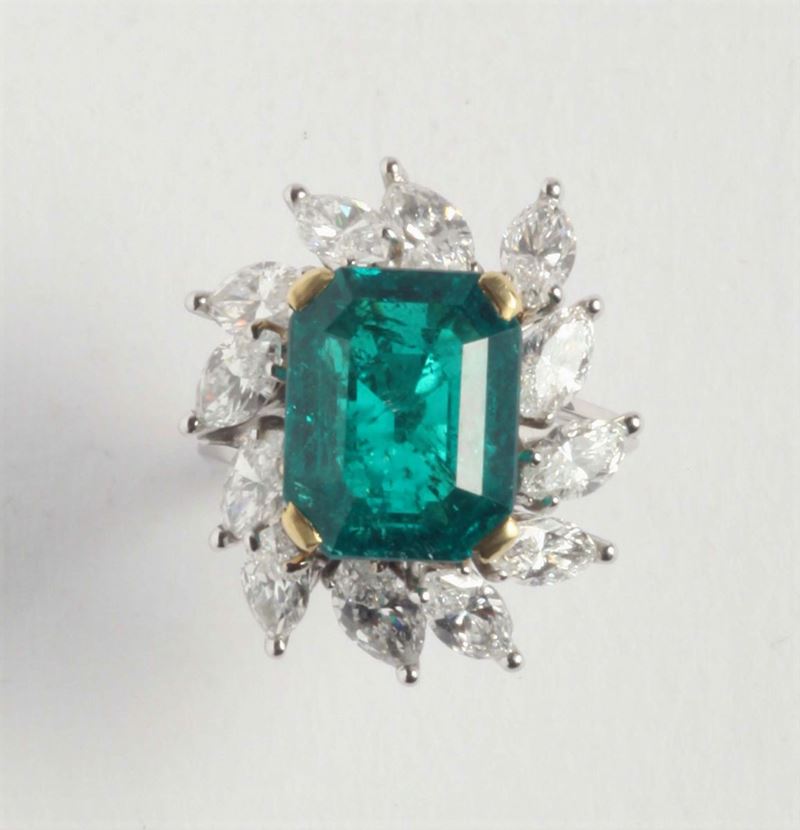 An emerald and diamond cluster ring. Accompanied by report of R.A.G laboratory stating that the emerald is of Colombian origin, with indications of insignificant clarity enhanncement weghing ct 6,90 circa  - Auction Silver, Ancient and Contemporary Jewels - Cambi Casa d'Aste