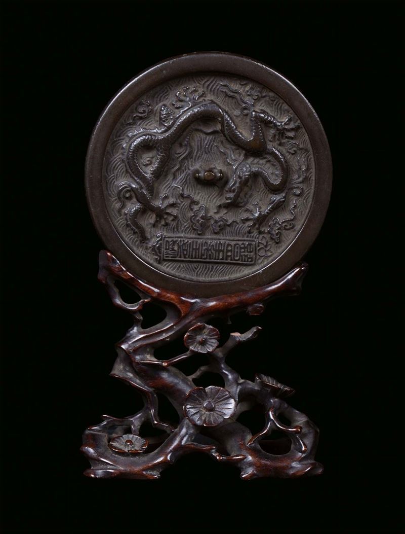 A silver plated bronze mirror with carved wood base, China, Ming Dynasty, 16th century  - Auction Furnishings and Works of Art from Important Private Collections - Cambi Casa d'Aste