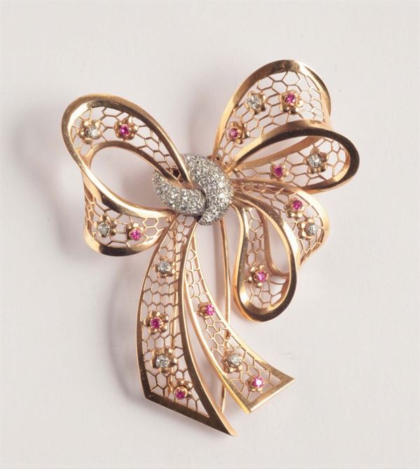 A ruby, diamond pavé and gold bow brooch. 1930 circa