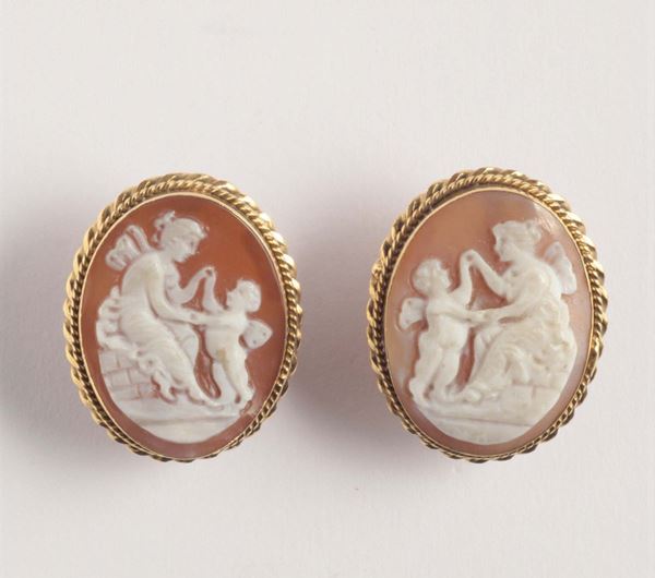 A pair of bulls mouth shell cameo and gold earrings. 1880 circa