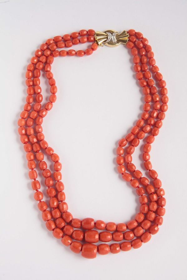 A coral necklace with gold and diamond clasp