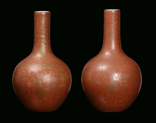 A pair of porcelain ampoule vases with orange background, China, Qing Dynasty, end 19th centuryGold vegetable decoration, apocryphal Qianlong mark