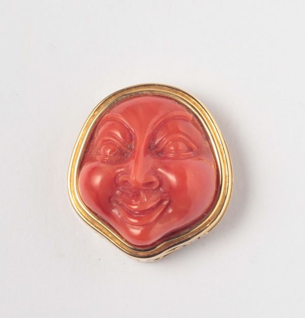 A coral carving and gold clasp