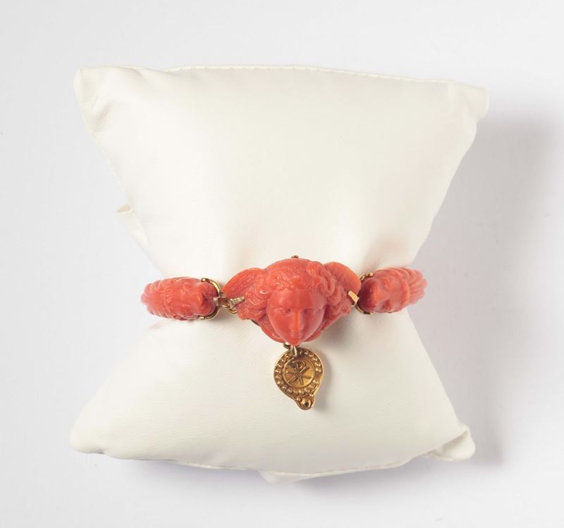 Bracciale in corallo raffigurante testa alata di medusa, sul pendente il simbolo Chi Rho  - Asta Argenti e Gioielli Antichi e Contemporanei - Cambi Casa d'Aste