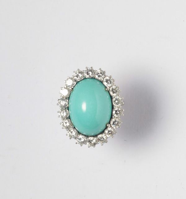 An oval cabochon turquoise and diamond cluster ring