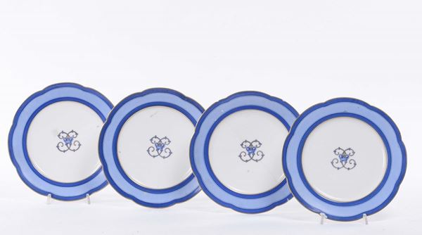 Lotto di quattro piatti in porcellana con stemma centrale