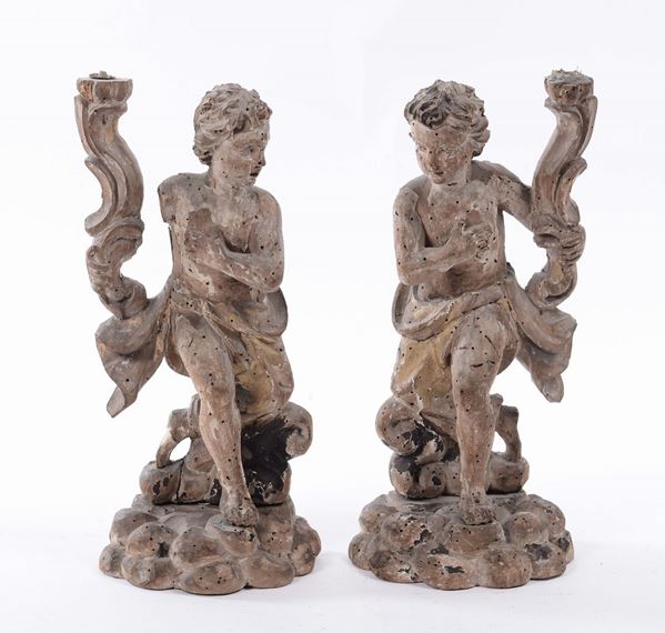 Coppia di piccoli putti reggicero in legno intagliato, XVIII secolo