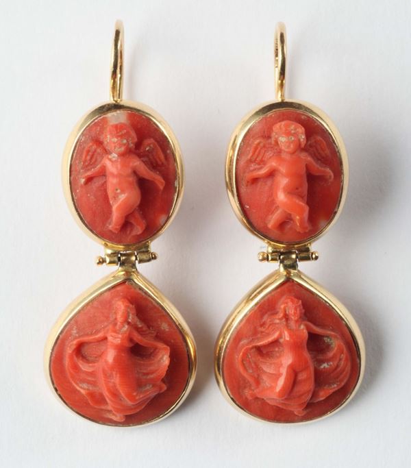 A pair of earrings with engraved coral
