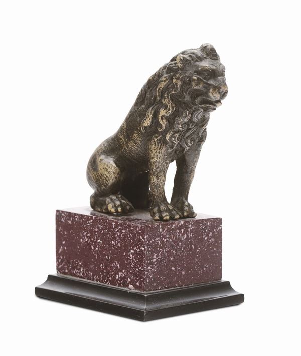 A molten and chiselled bronze sitting lion on a porphyry base, northern Italian or German art, 17th century