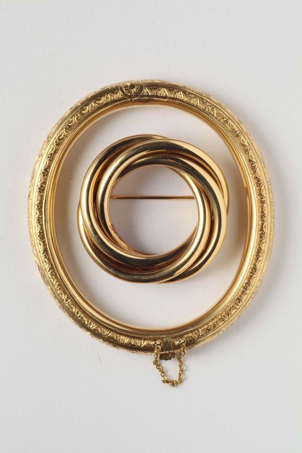 A gold and carved bangle with a gold brooch