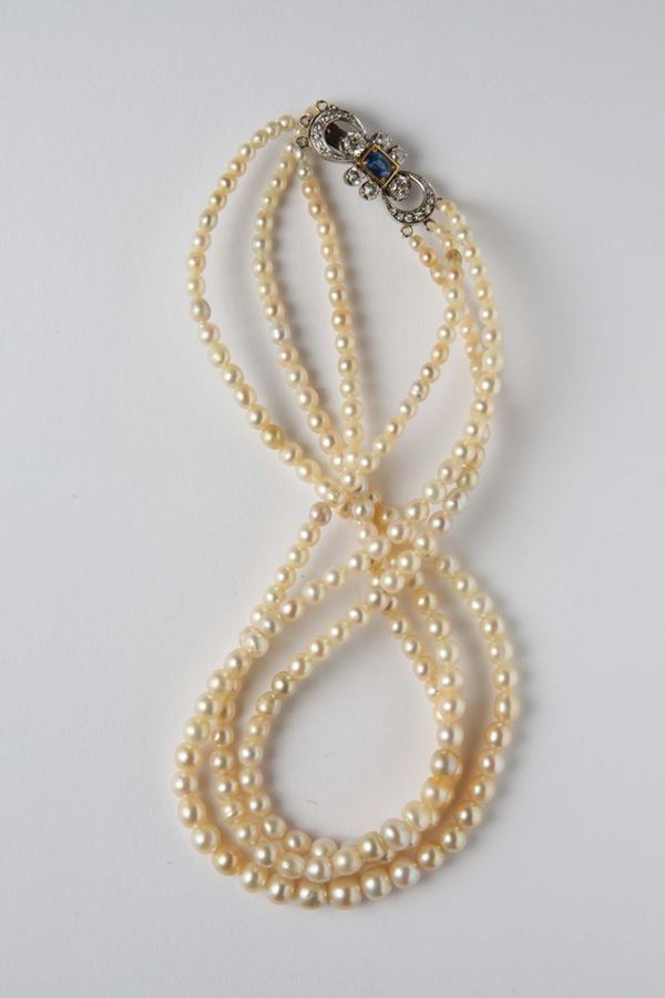 A three-row natural pearl necklace with diamond and sapphire clasp