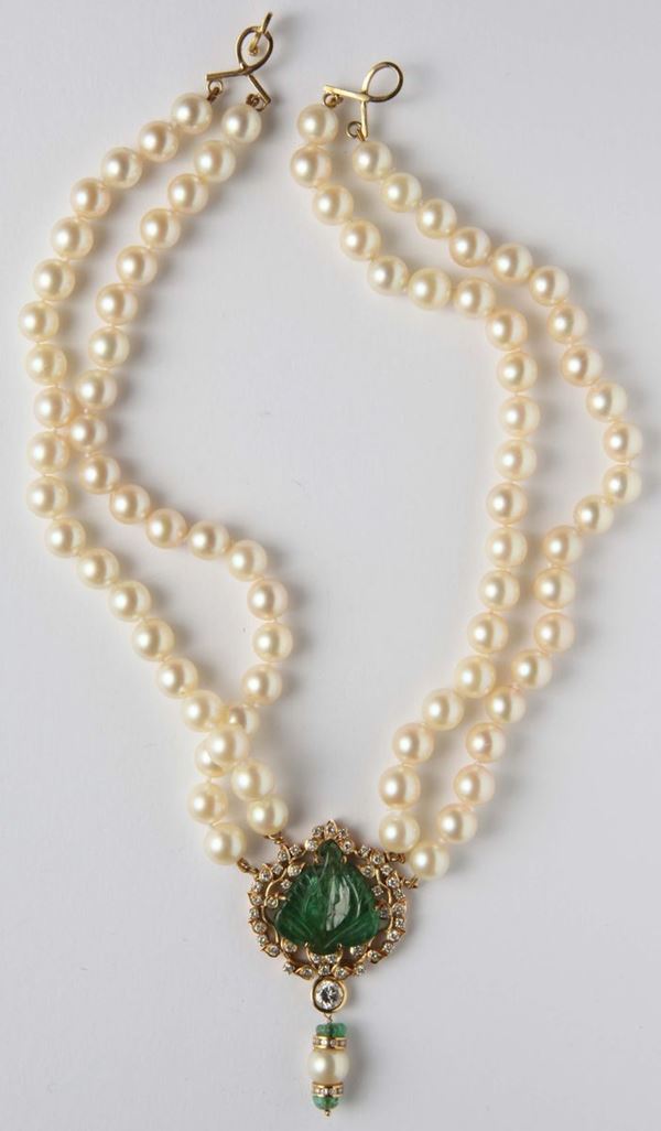 A double row necklace of cultured pearl connected at the centre by an emerald carved