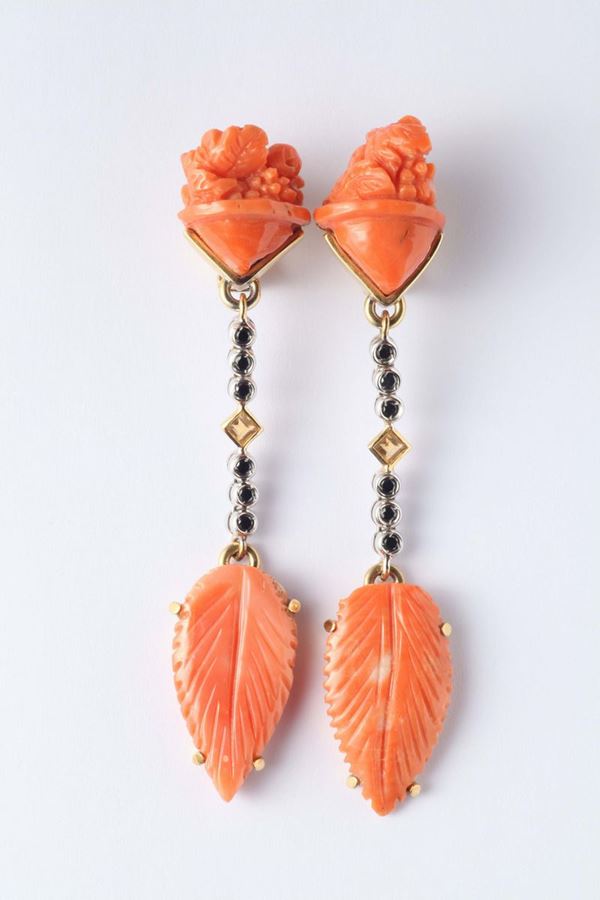A pair of carved coral, sapphire and gold pendent earrings