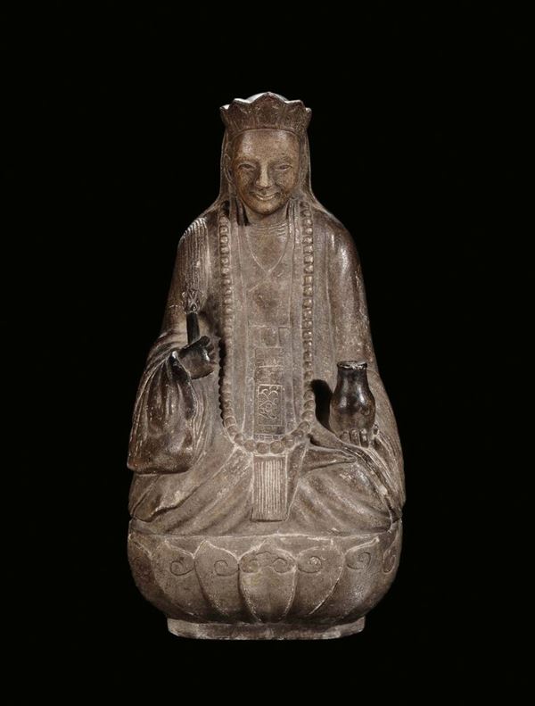 A carved stone divinity on lotus flower, China, Ming Dynasty, 17th century