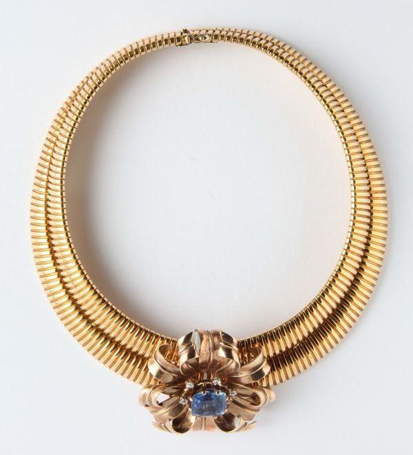 A sapphire and gold brooch with a gold necklace