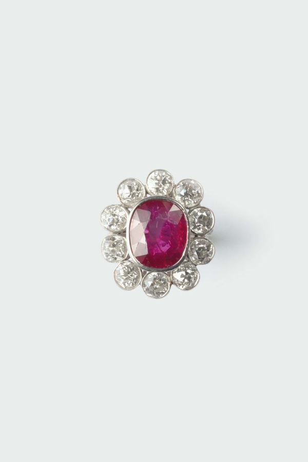 A ruby and diamond cluster ring. The ruby weighing ct 5,00 circa. No indicationf of heating (NTE)