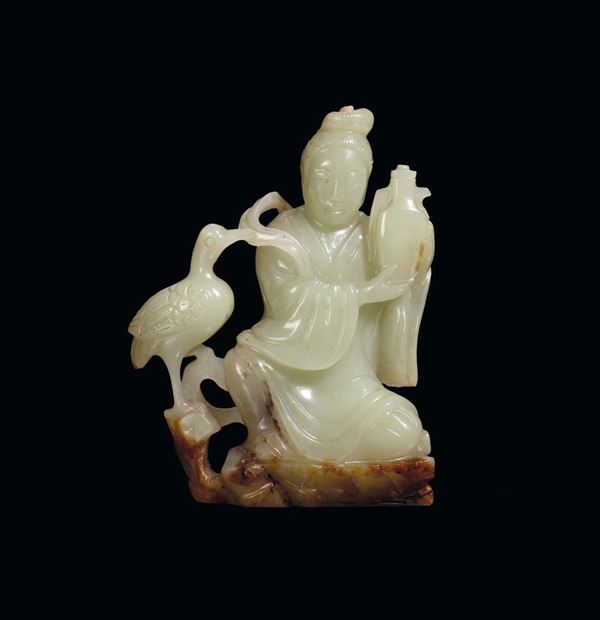 A small yellow jade and russet carving of Guanyin with bird,  China, Qing Dynasty, late 19th century