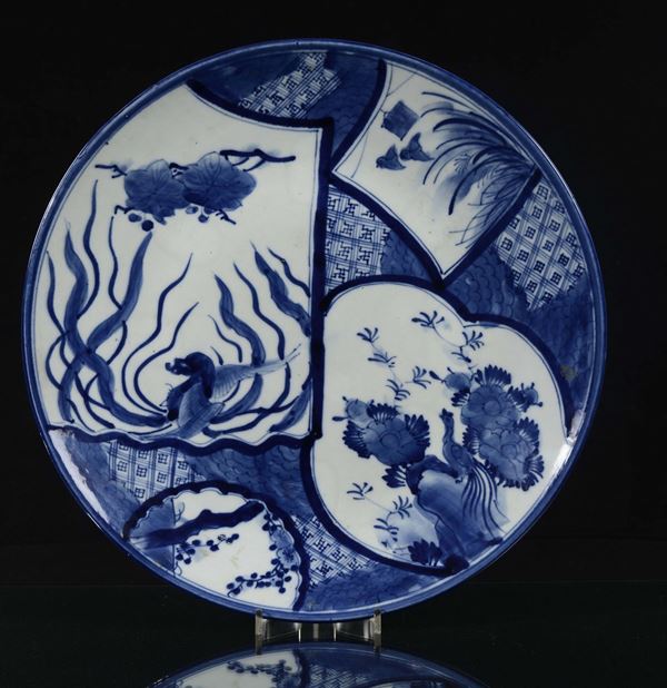 Coppia di grandi piatti in porcellana bianca e blu con scene naturalistiche, Giappone, XIX secolo