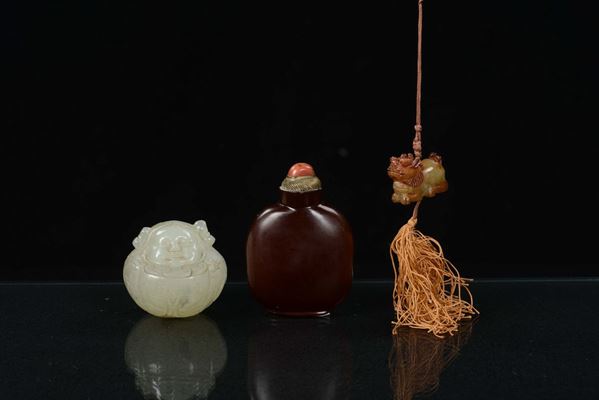A lot formed by a small white jade, a Pho dog yellow jade and a cornelian snuff bottle, China, Qing Dynasty, 19th century