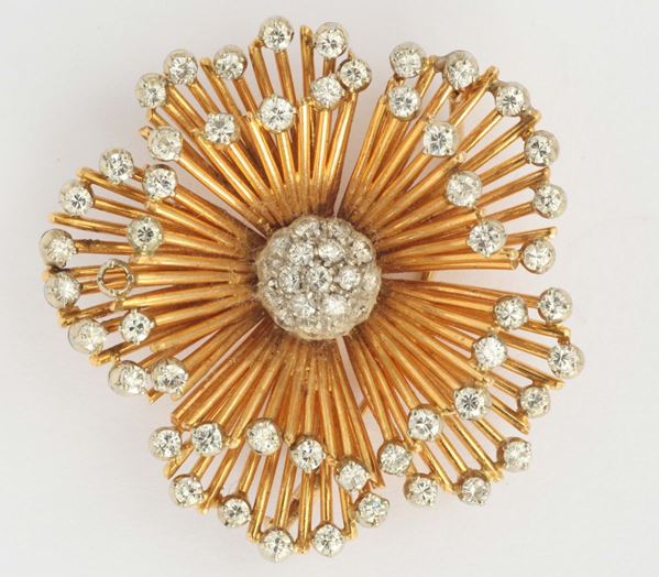 A diamond and gold flower brooch