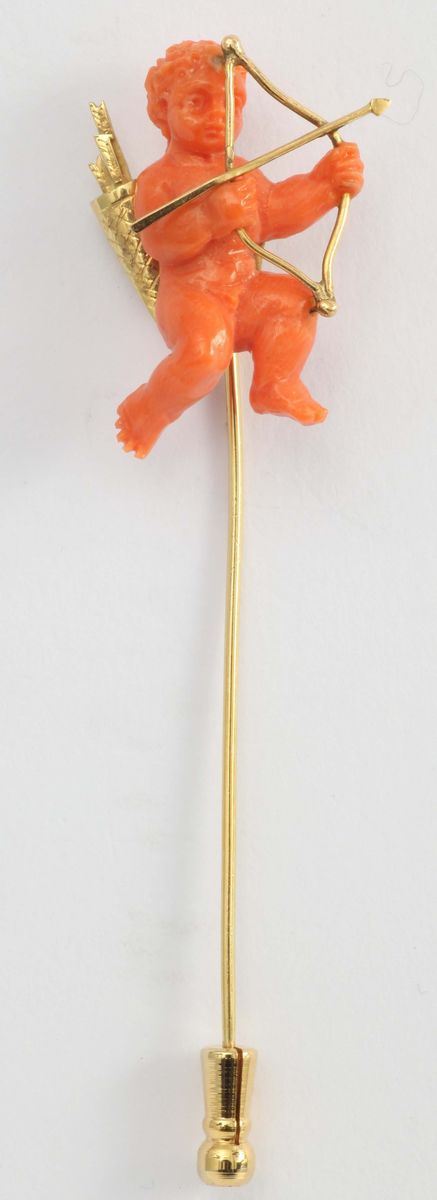 A coral and gold tie-pin