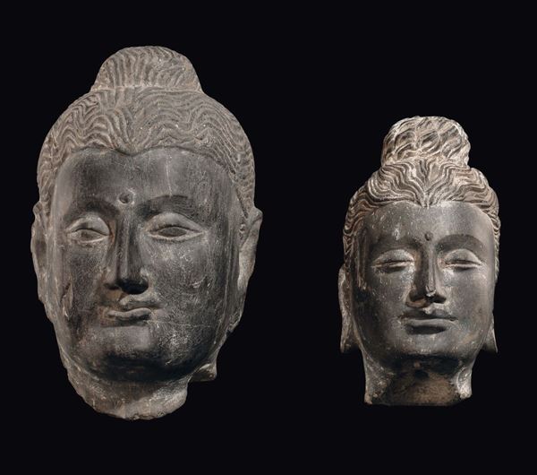A pair of “Khmer divinities” stone heads, Cambodia, 19th century