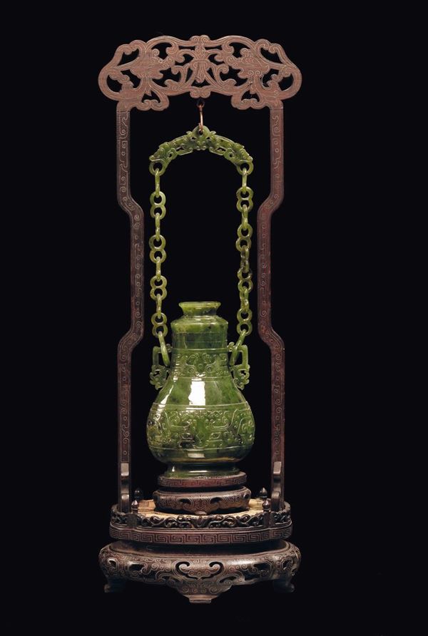 A small spinach green jade vase with chain and wooden base, China, Qing Dynasty, 19th century